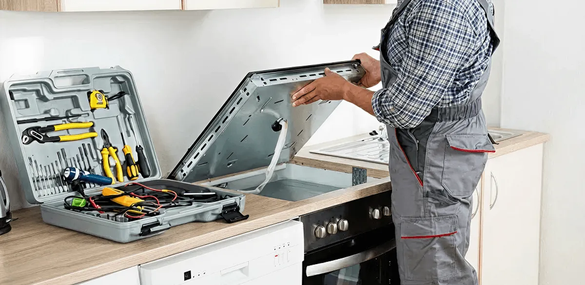 Handyman repairing a cooktop and checking wiring connections in Pueblo, CO